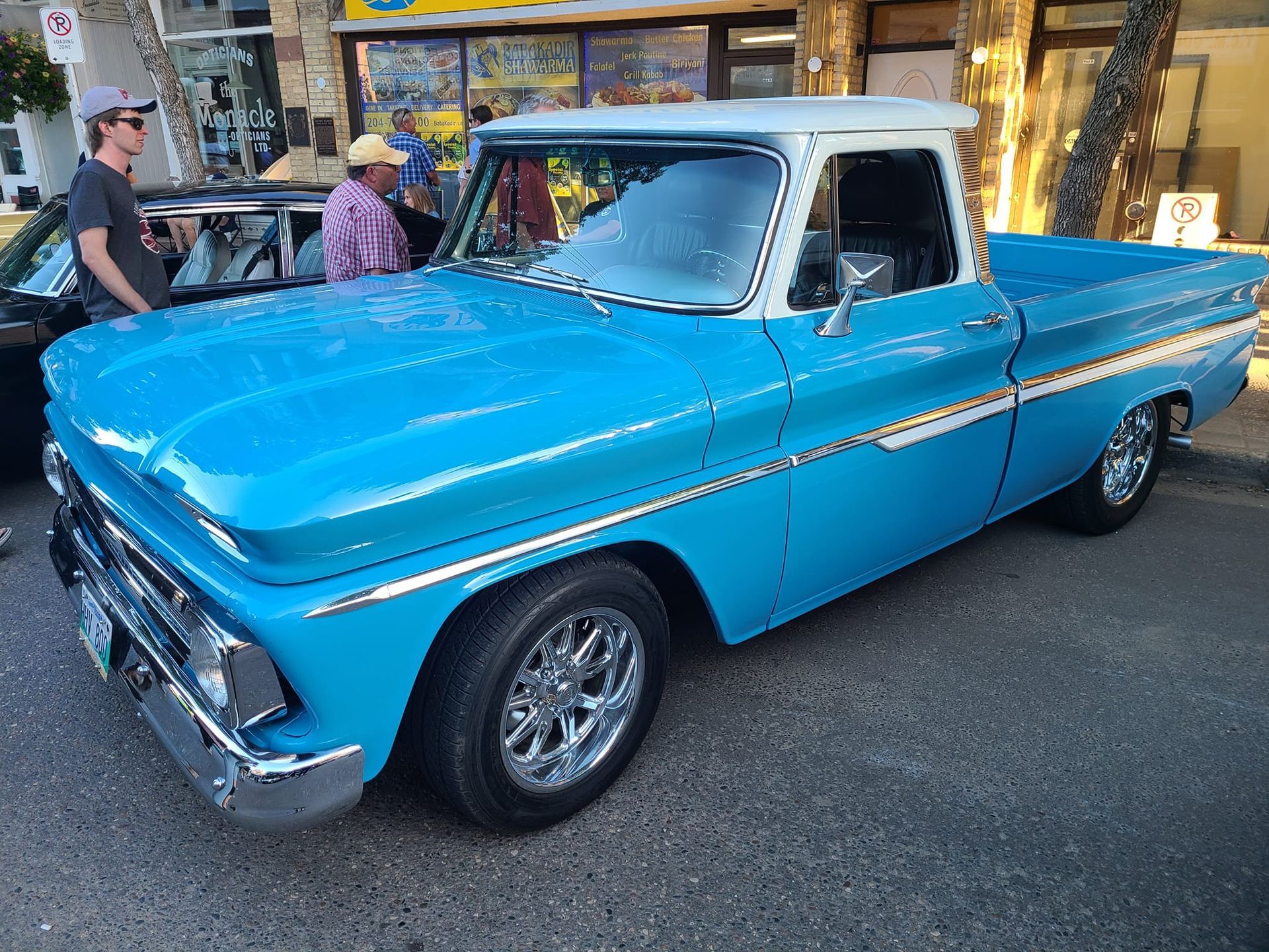 A blue pickup truck is parked on the side of the road.