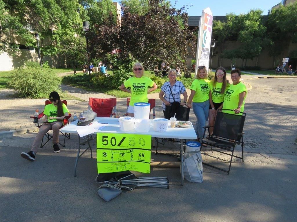 A group of people are standing around a table.