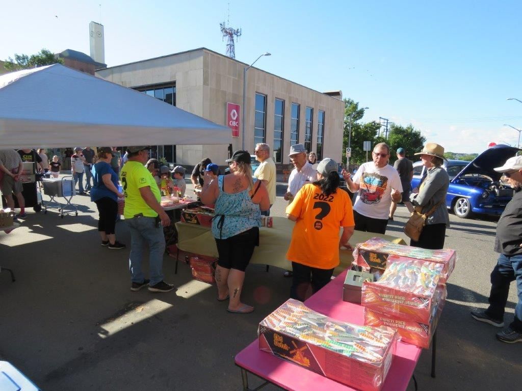 A group of people are standing around a table with boxes of fireworks.