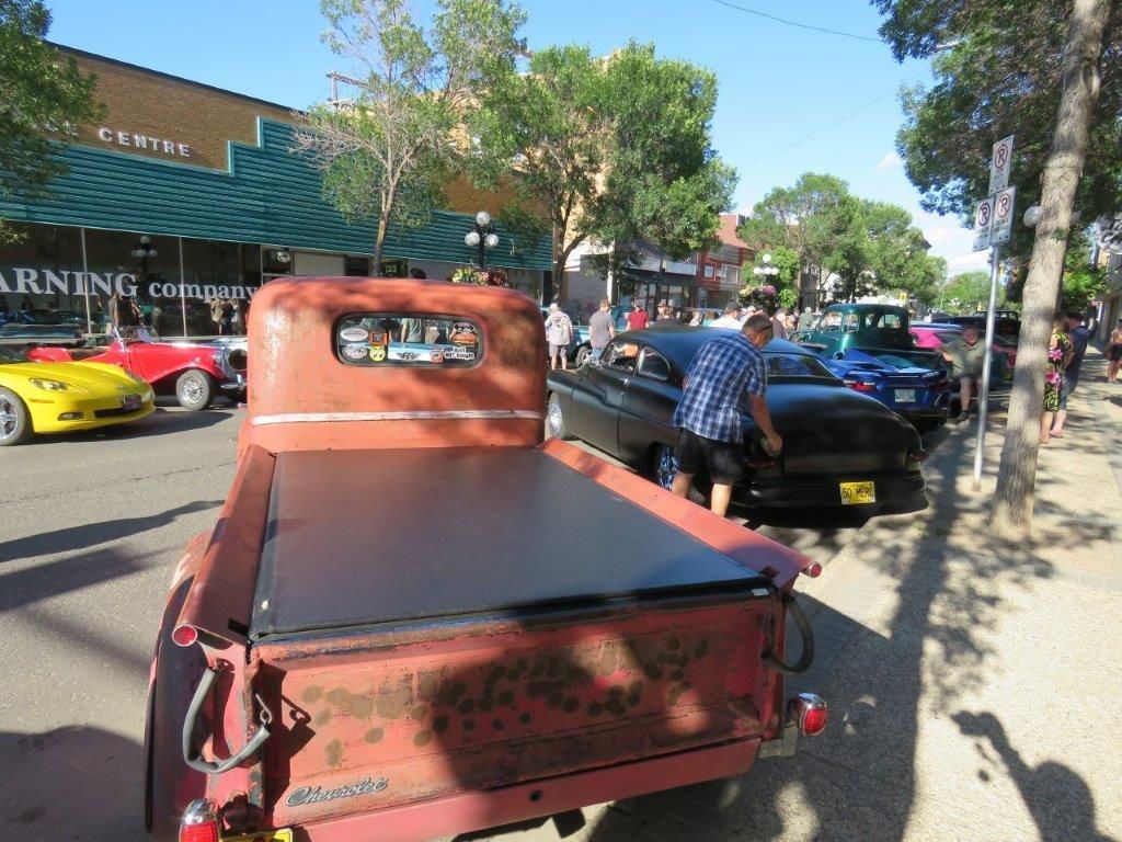 An old truck is parked on the side of the road