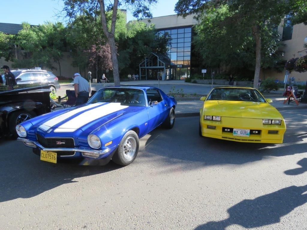 A blue car and a yellow car are parked next to each other