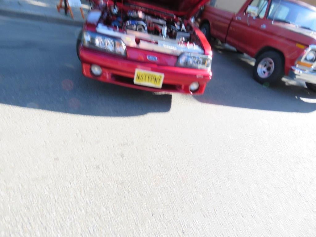 A red ford car with a license plate that says ' nv ' on it