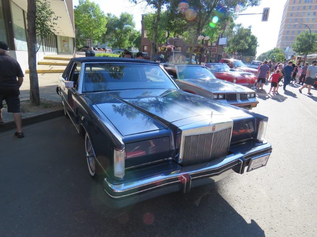 A black car is parked on the side of the road.