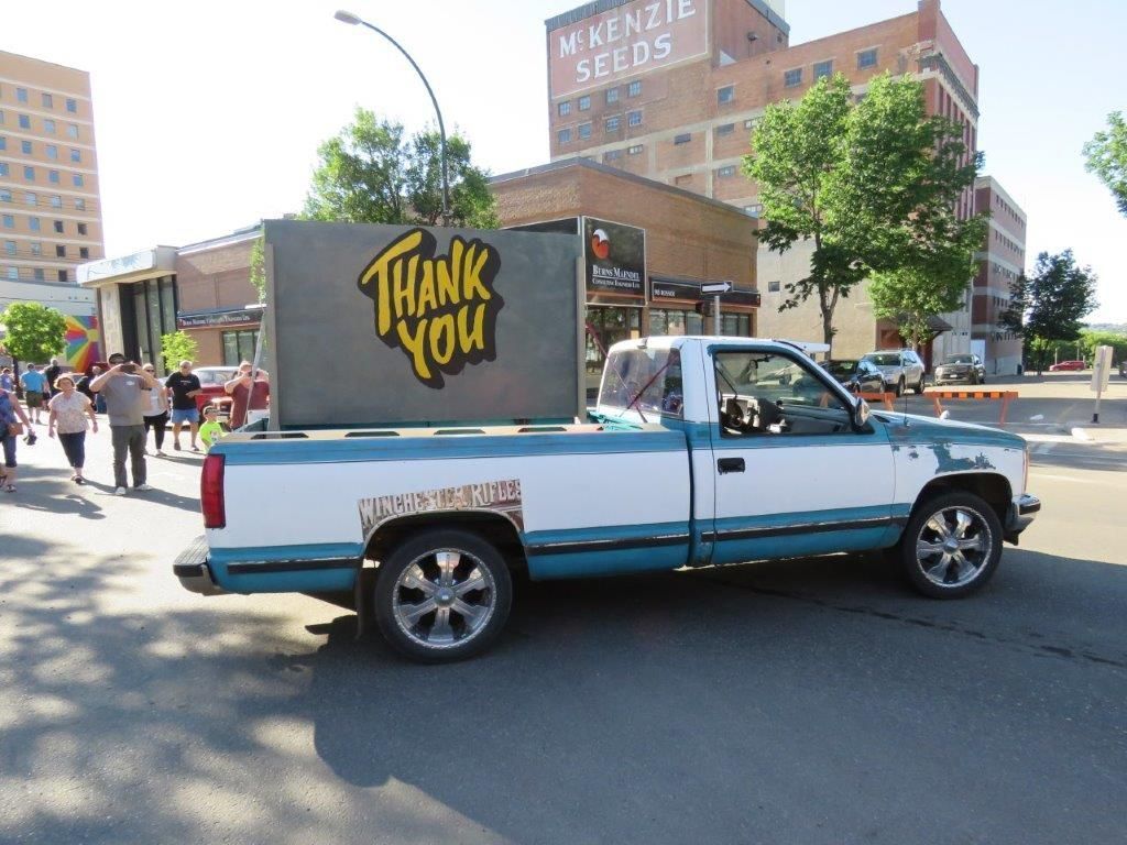 A truck with a sign on the back that says thank you