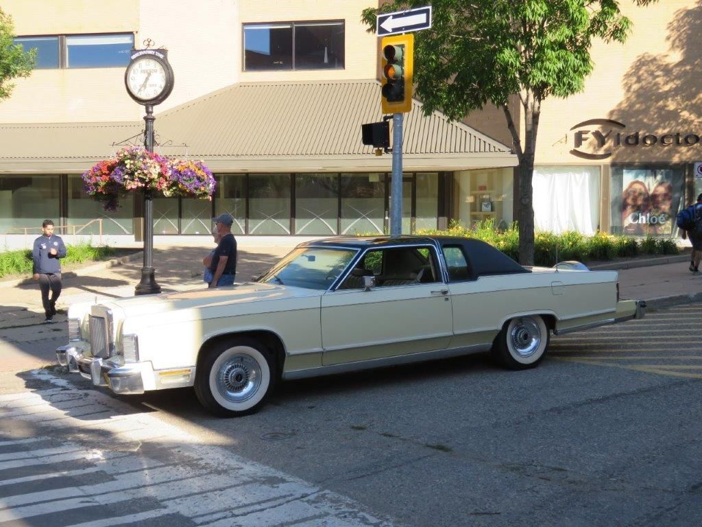 A white car is parked on the side of the road