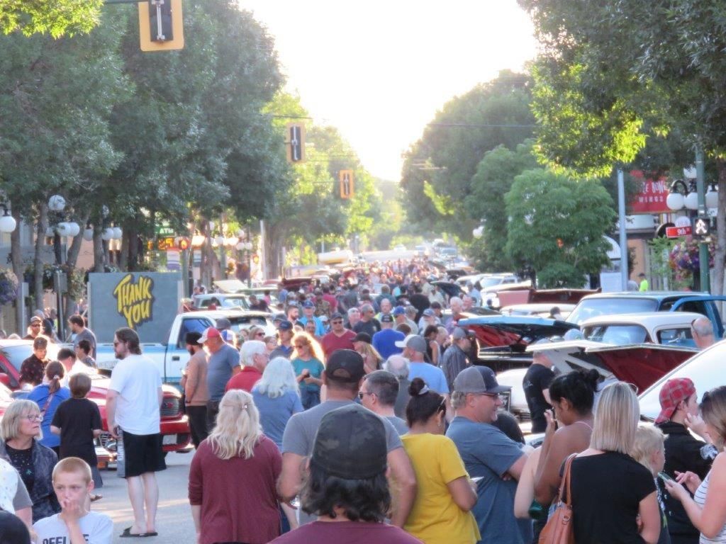 A crowd of people are walking down a busy street.