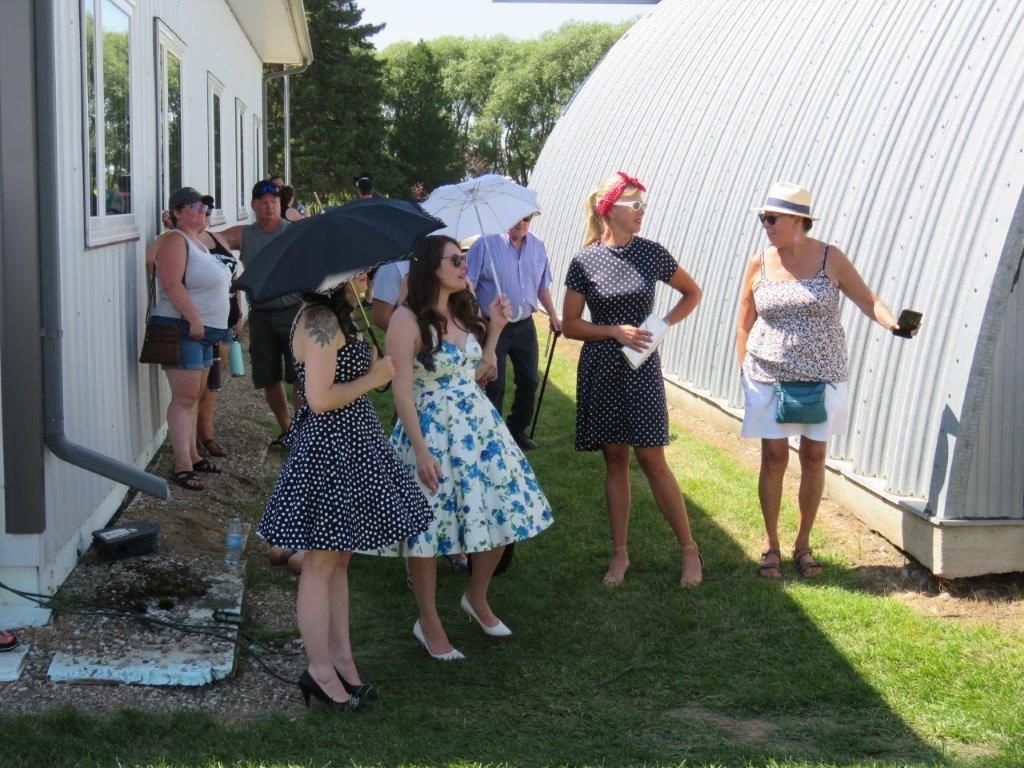 A group of women standing in front of a building holding umbrellas