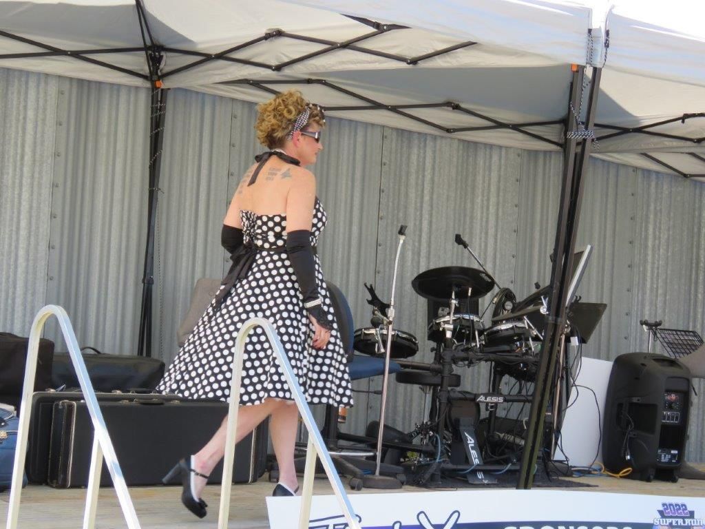 A woman in a black and white dress is standing on a stage