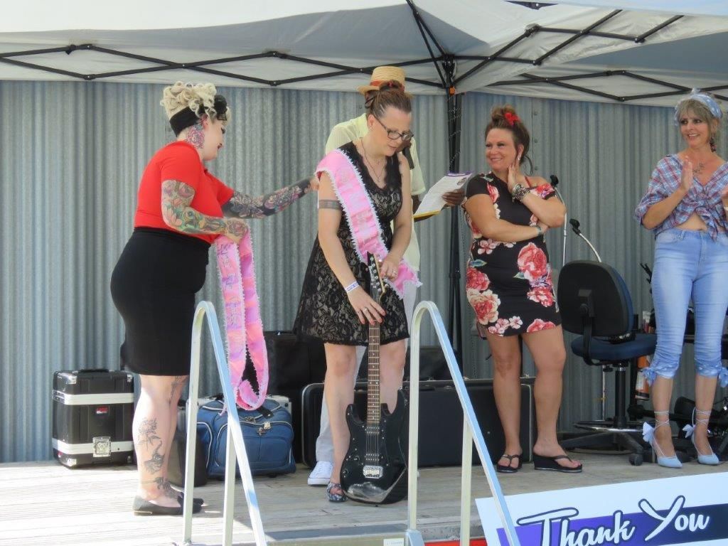 A group of women are standing on a stage in front of a thank you sign.