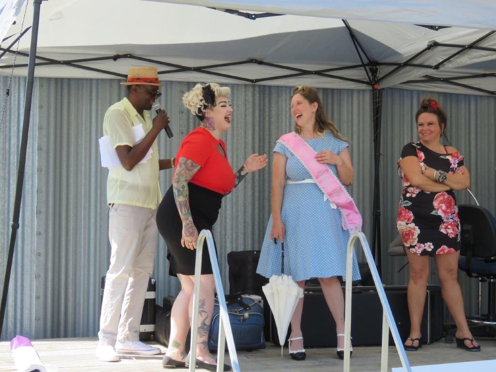 A group of women are standing on a stage talking to each other.