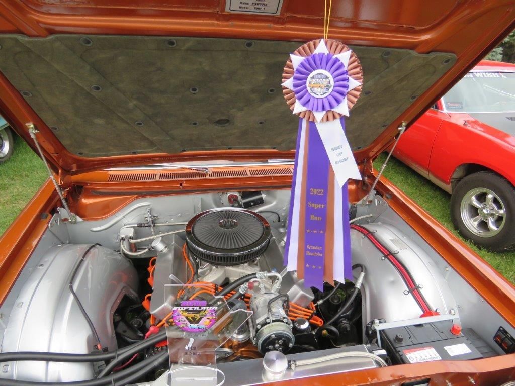 A purple ribbon hangs from the hood of a car