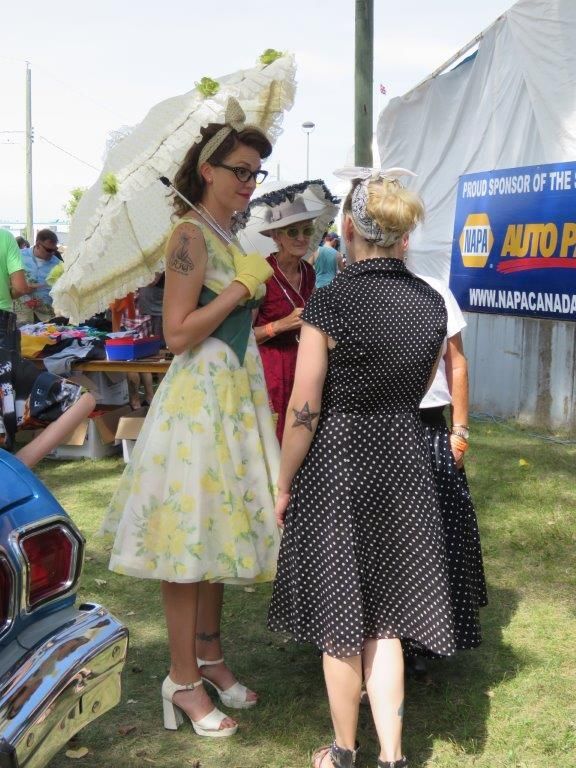 A group of women are standing in front of a napa auto parts sign