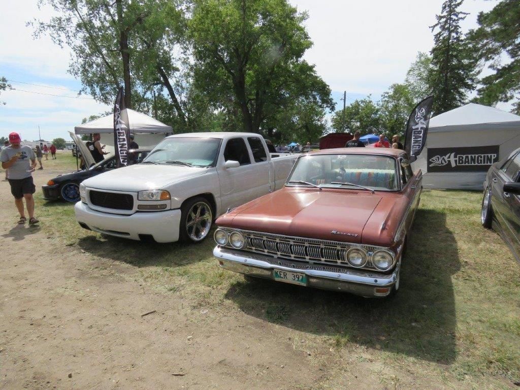 A white truck and a brown car are parked next to each other