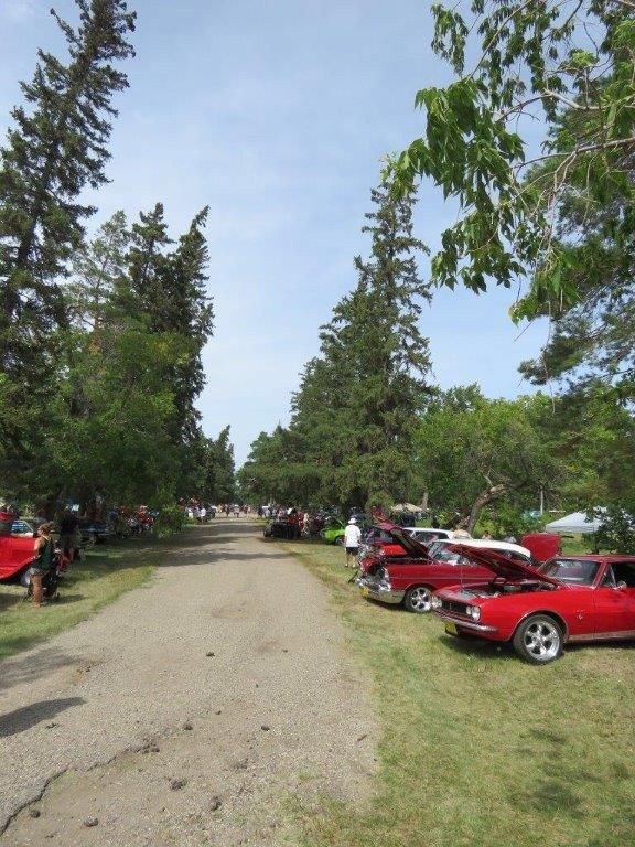 A row of red cars parked on the side of a road
