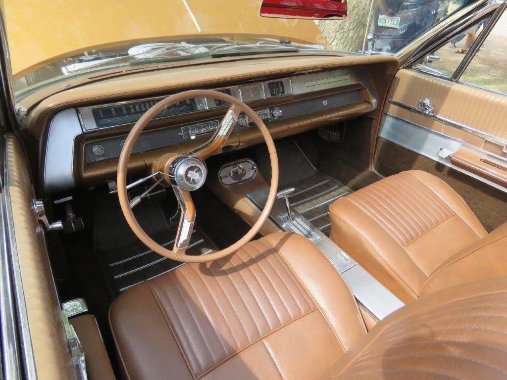 The interior of an old car with brown leather seats and a steering wheel