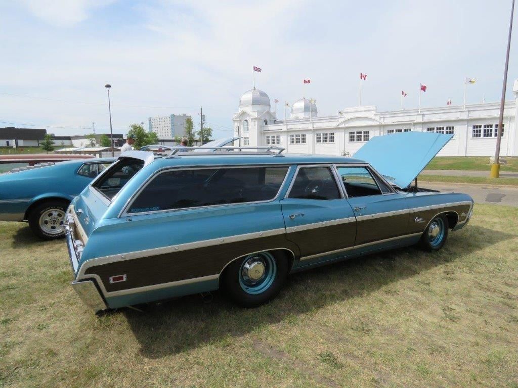 A blue and brown station wagon with the hood up