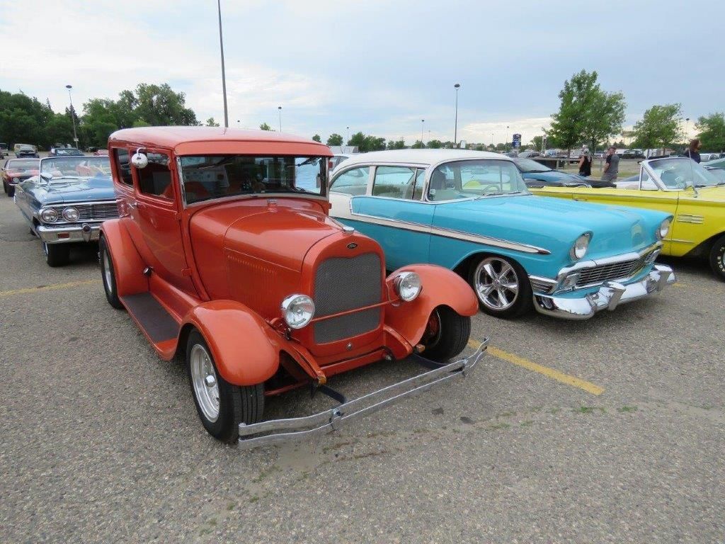 A red car is parked next to a blue car in a parking lot.