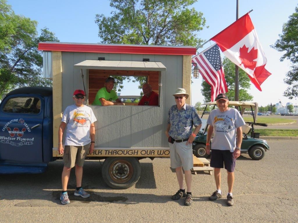 A group of men are standing in front of a truck that says uk through canada