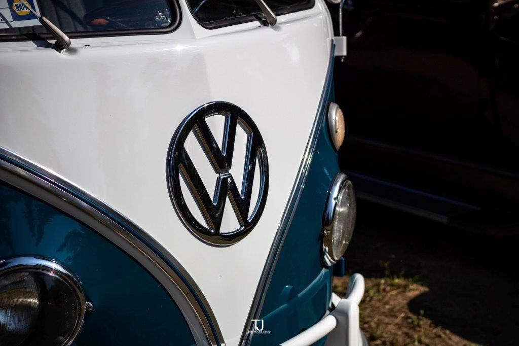 A close up of the front of a blue and white vw bus.