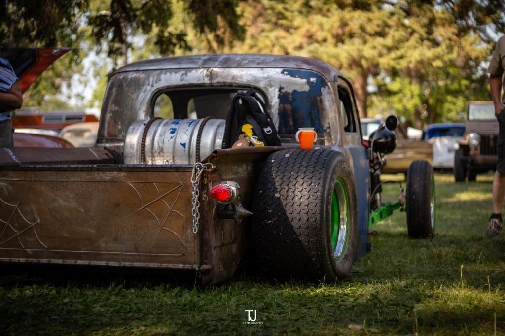 A dirty truck is parked in the grass in a field.