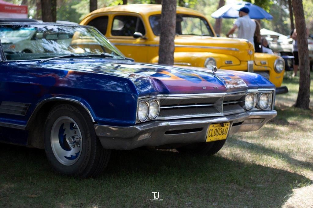 A blue car is parked next to a yellow car.