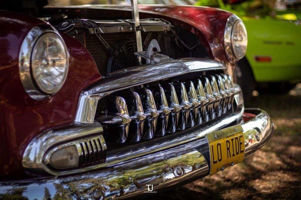A close up of a red car with a license plate that says lo ride.