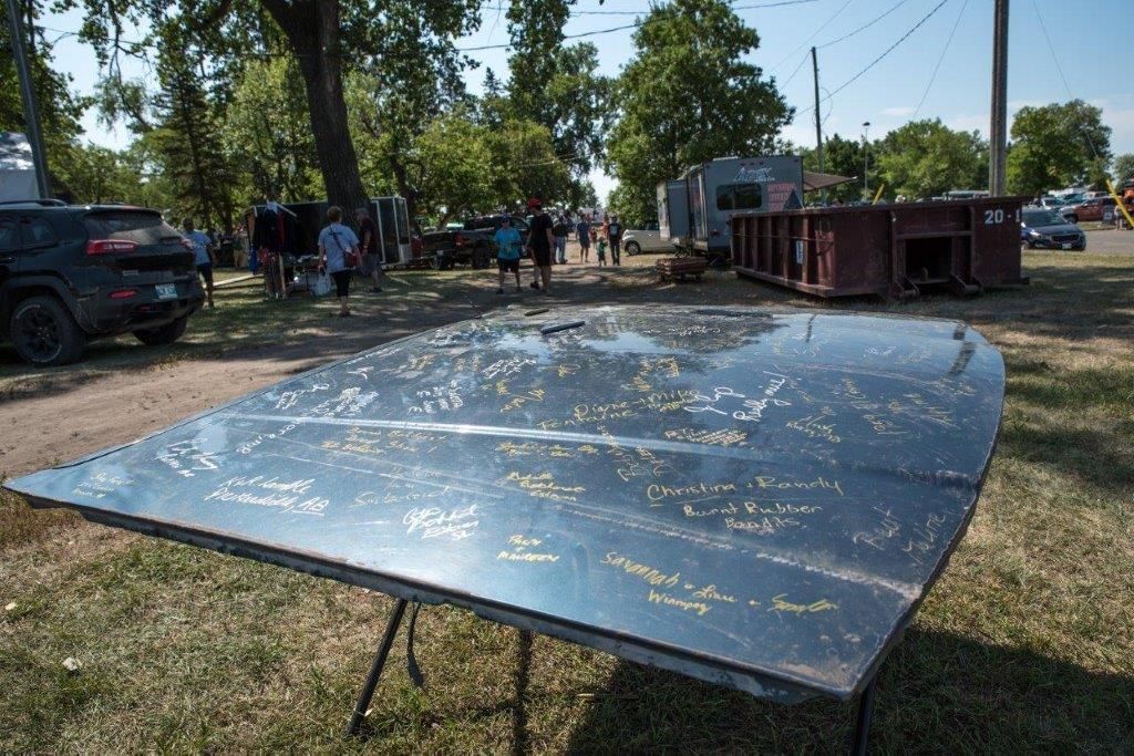 A large metal table is sitting on top of a lush green field.