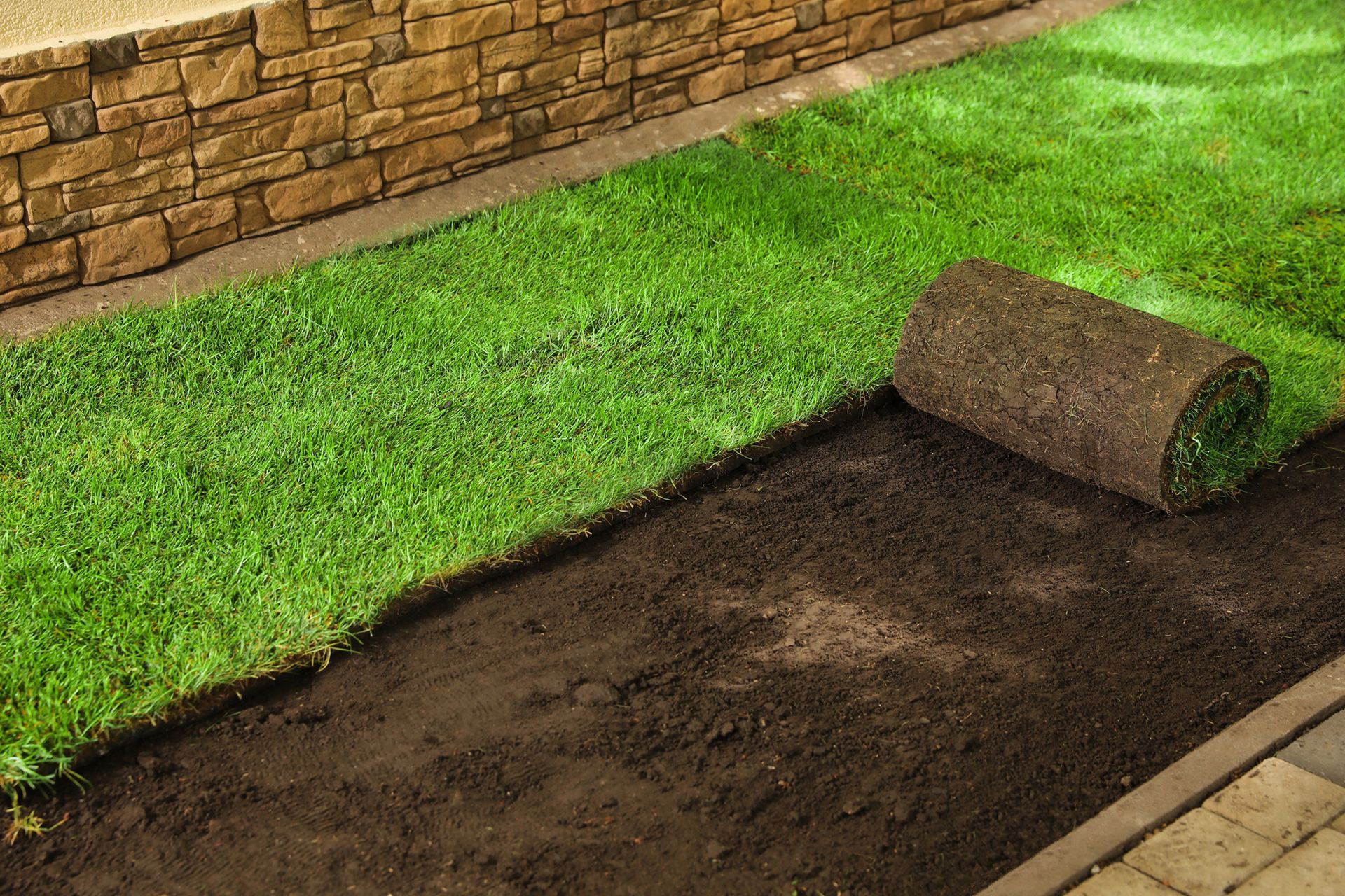 a roll of turf is sitting on top of a lush green lawn .