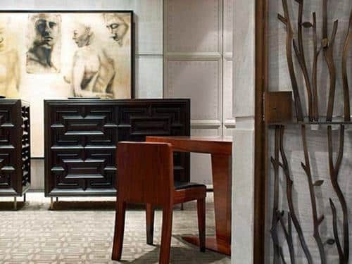Modern dining room with dark wood table, chairs, abstract art, and decorative branch display