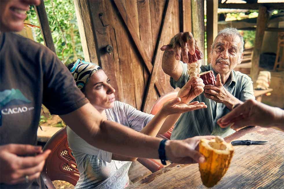 Friends raising glasses around a rustic wooden table in a cozy, open-air café