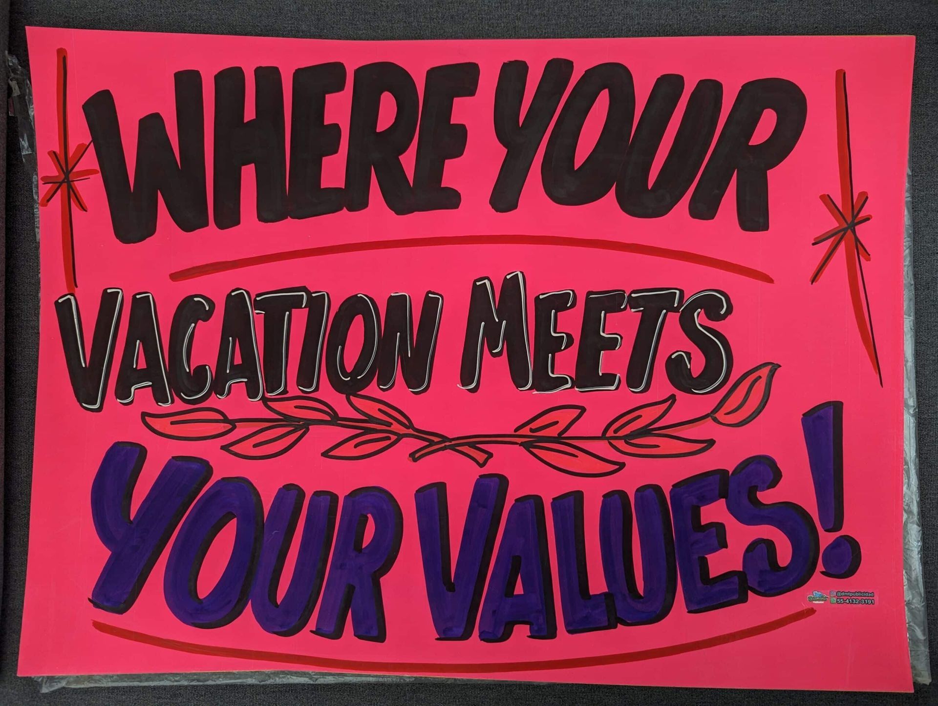 Pink poster reading “WHERE YOUR VACATION MEETS YOUR VALUES!” in bold black and blue text.