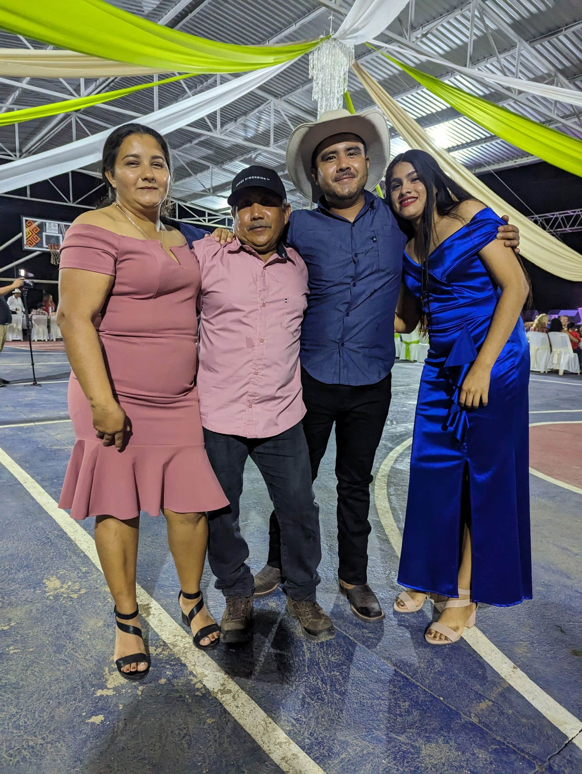 Four people posing together at a decorated outdoor event, smiling at the camera.