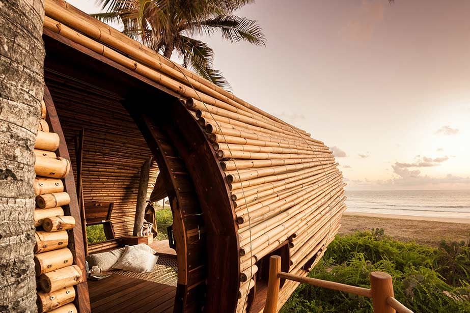 Wooden beach hut with palm trees and ocean view at sunset