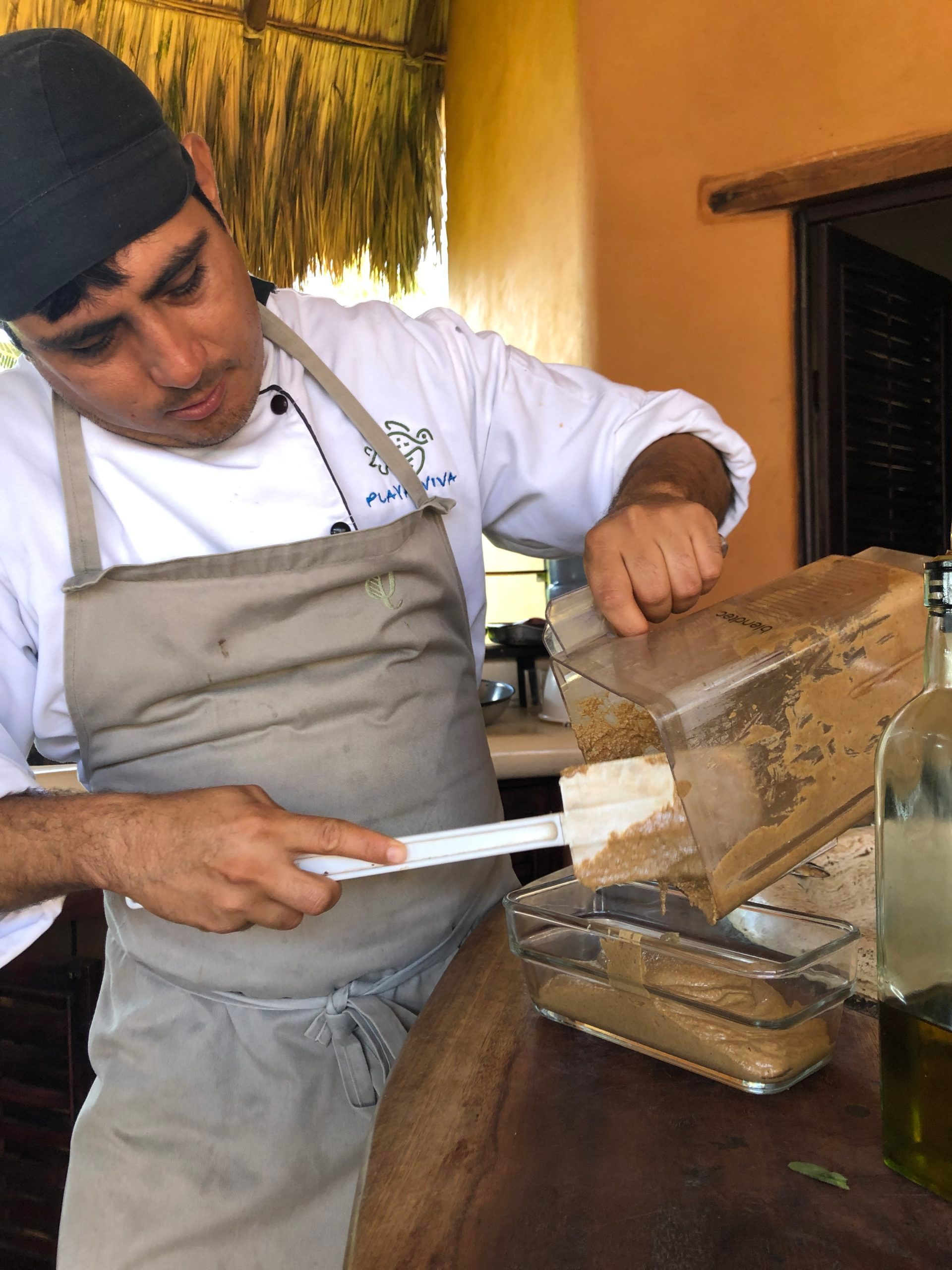 Chef slicing bread beside a countertop in a warm-toned kitchen