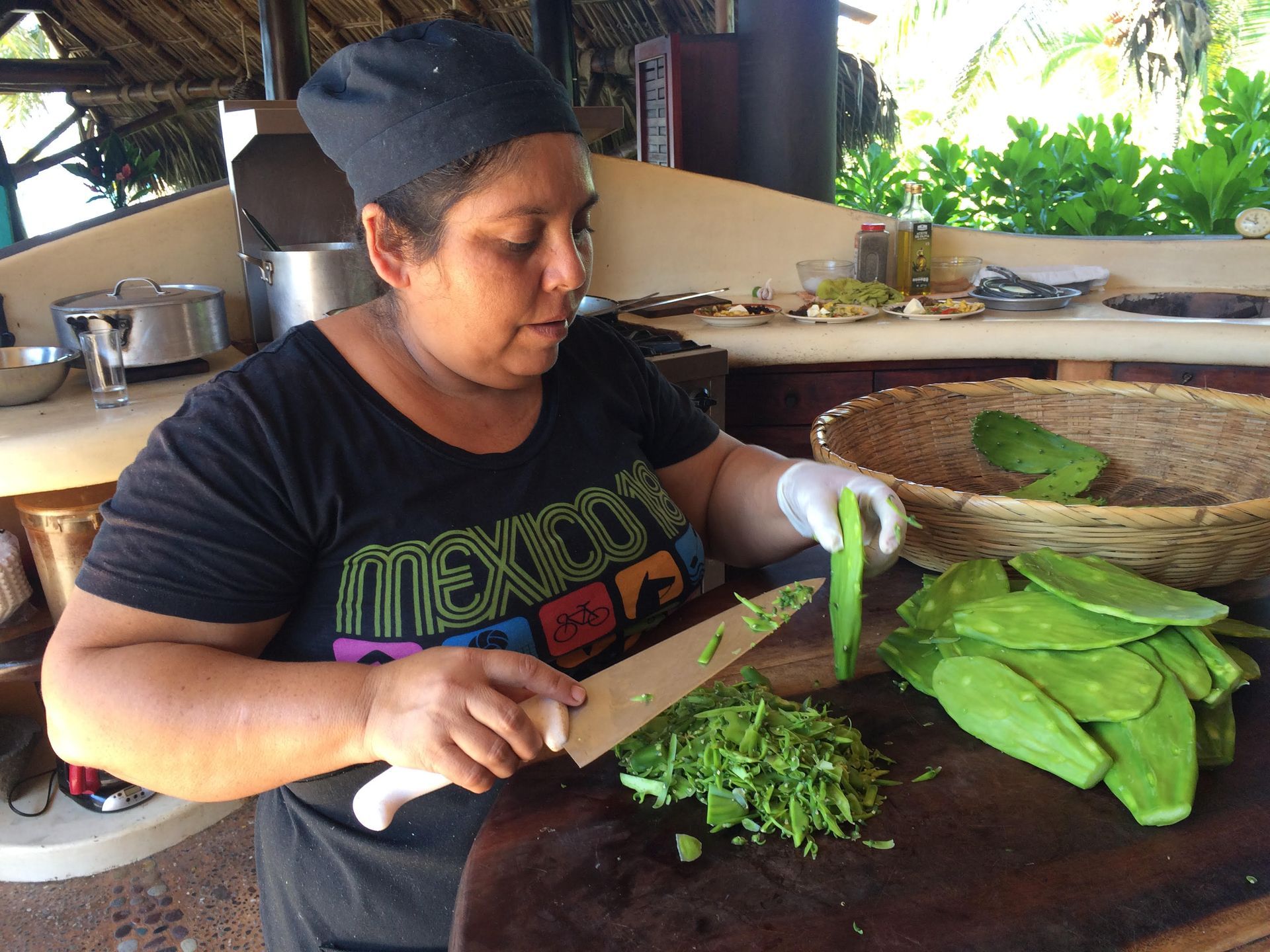 Person chopping green vegetables at a kitchen counter with a knife