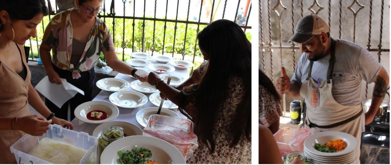 People sharing a meal at a table outdoors, serving food and talking in a shaded patio.
