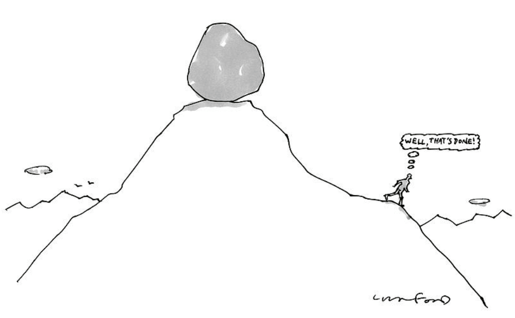 Large boulder balances atop a mountain peak beside a tiny sign on the right slope.