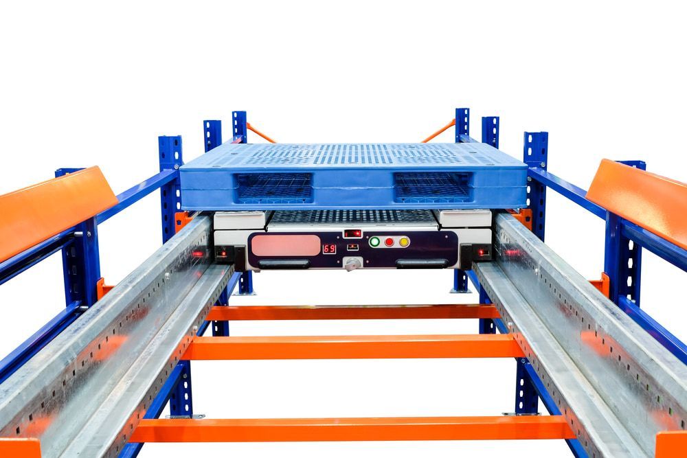 A Blue Pallet Is Being Loaded Onto A Conveyor Belt In A Warehouse — Wylec In Newcastle, NSW