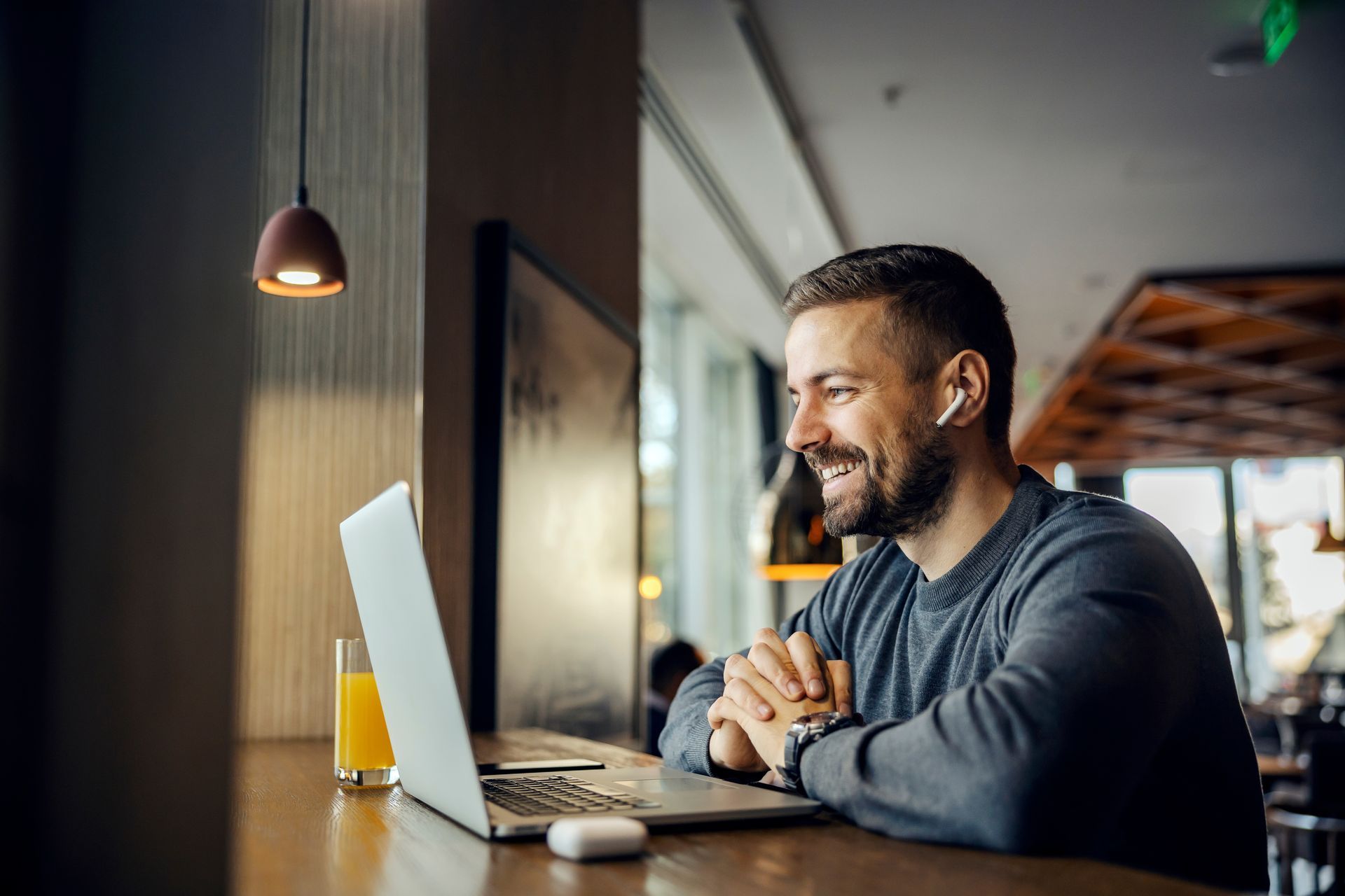 Picture of a man working on his work-issued laptop in a coffee shop