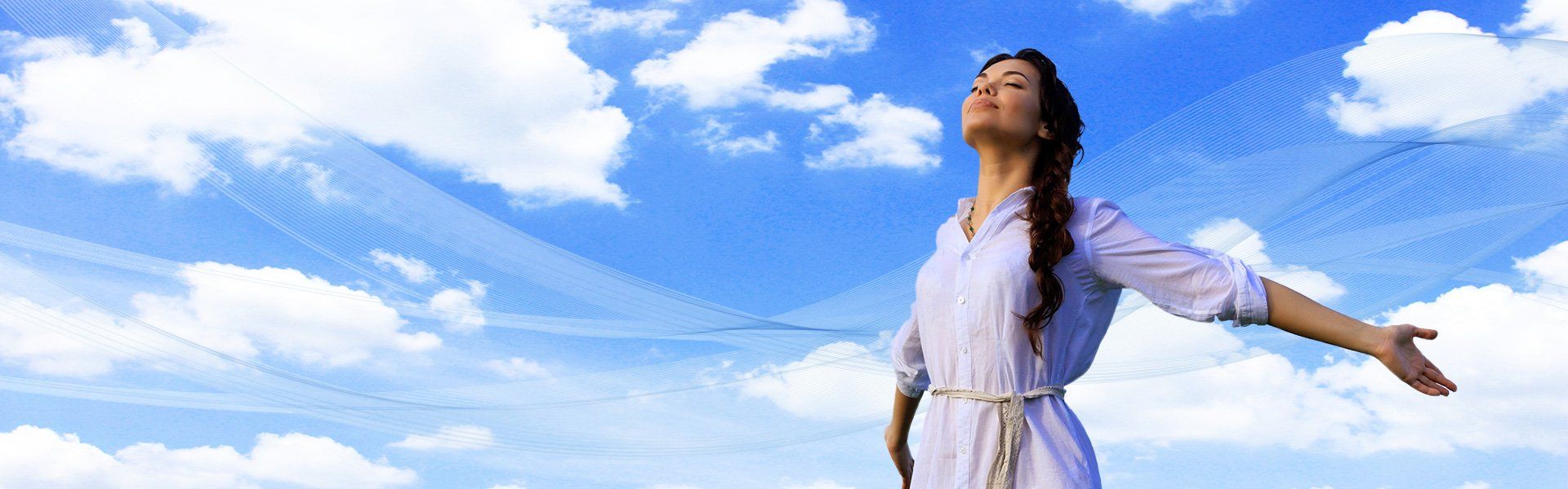 Woman in white dress with arms outstretched, eyes closed, against a blue sky with clouds.
