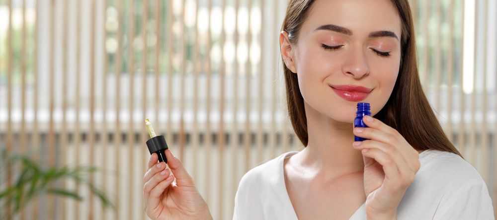 fragrance A woman is smelling a bottle of essential oil.