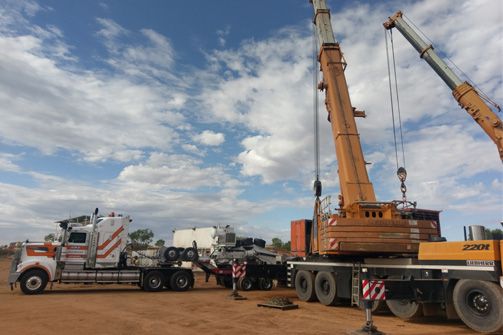 A Truck Is Being Towed by A Large Crane — Linmar Cranes & Haulage in Mt Isa, QLD