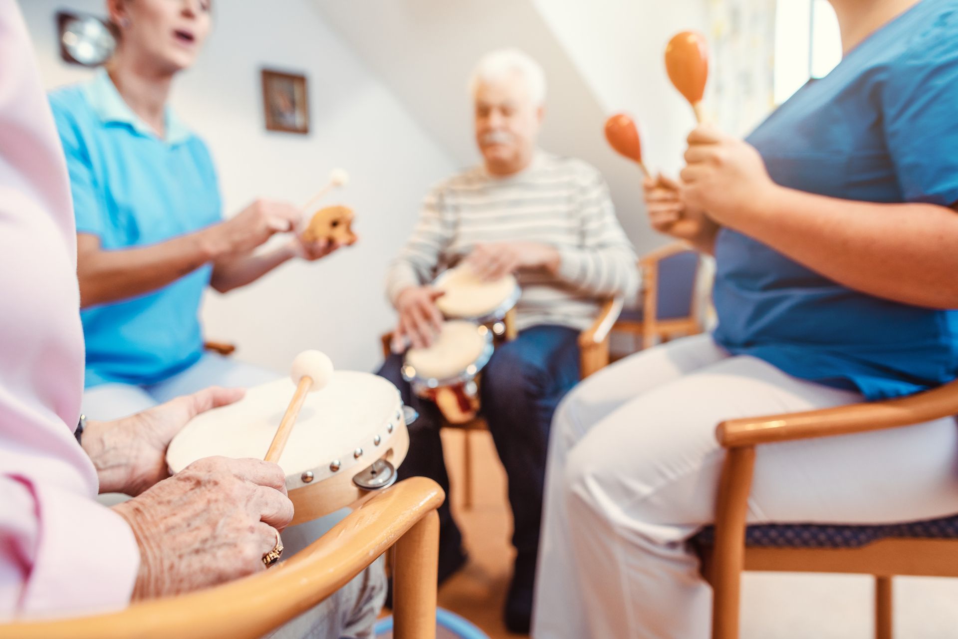 Gruppo di persone che suonano strumenti in una stanza; sono visibili un tamburello, maracas e tamburi.