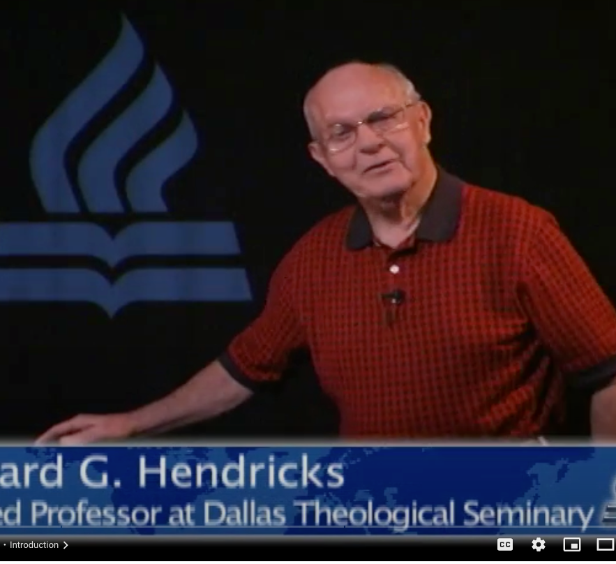 A man stands in front of a dallas theological seminary logo