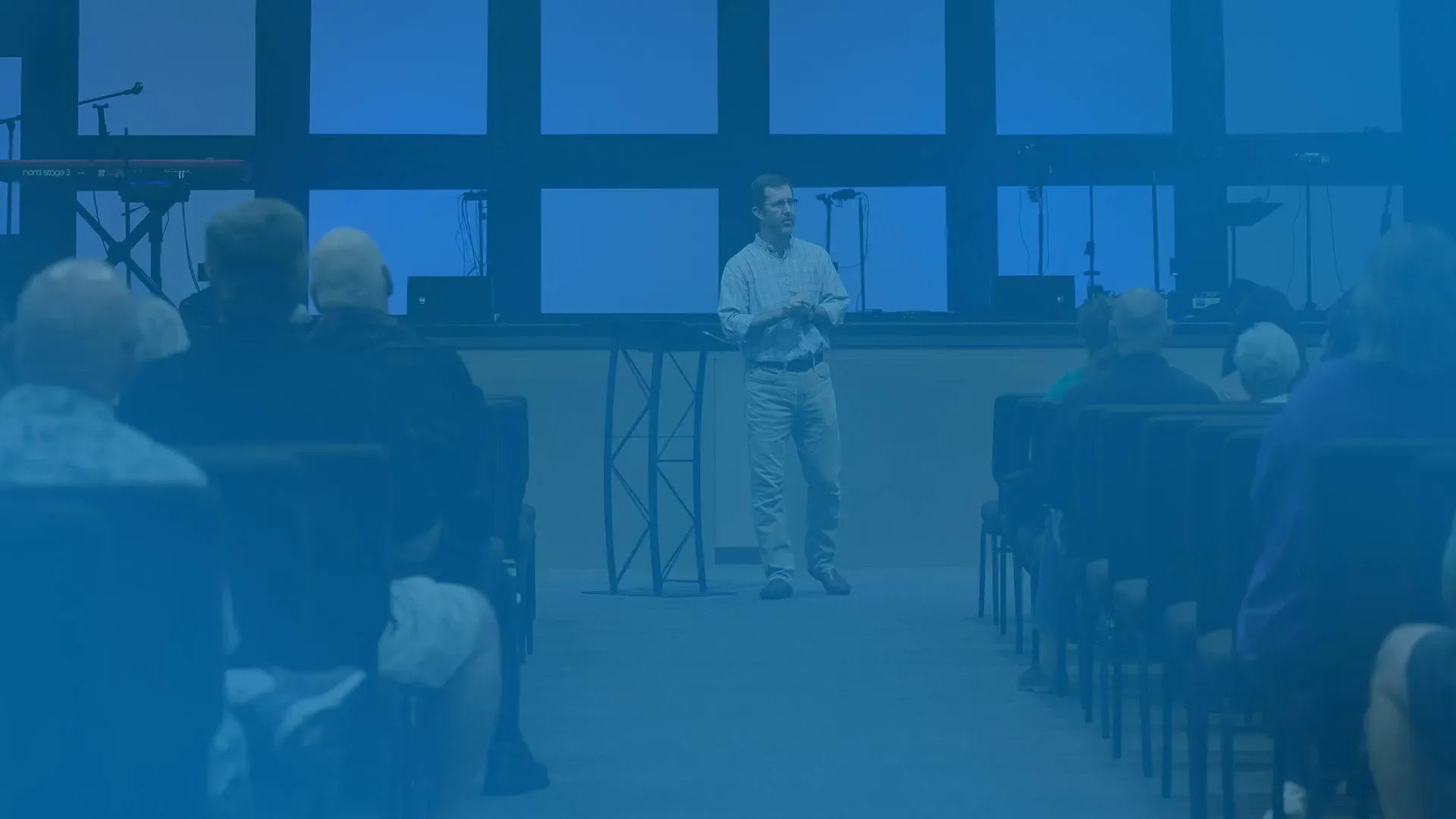 A man is giving a speech in front of a group of people in a church.