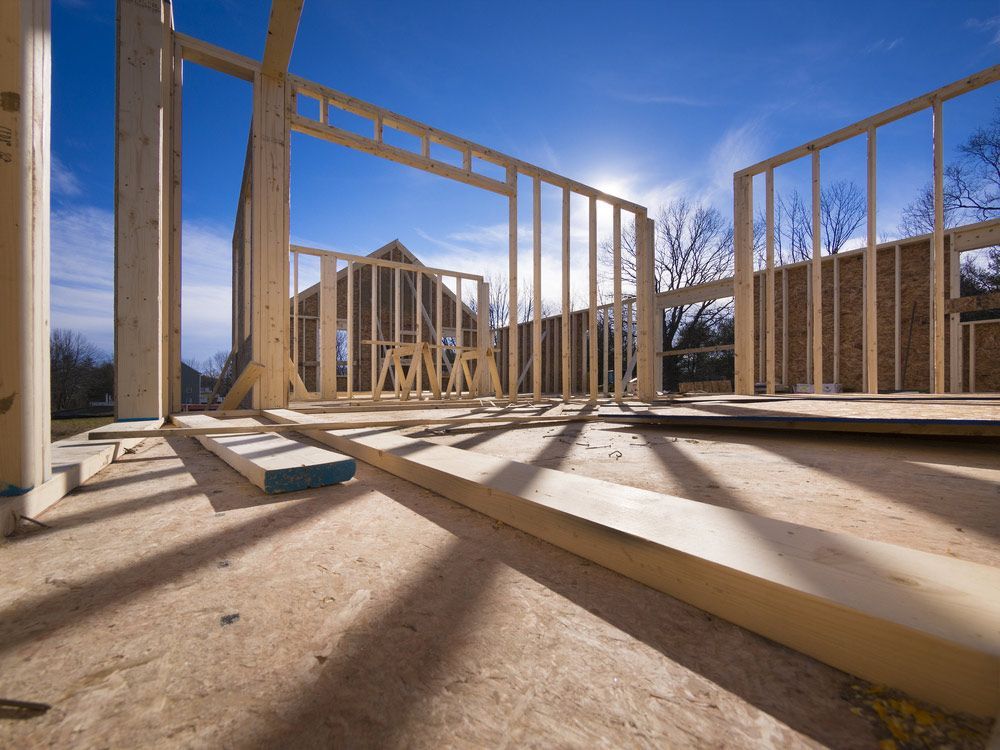 A House Is Being Built With Wooden Beams And A Blue Sky In The Background — Trussted Frames & Trusses in Taree, NSW