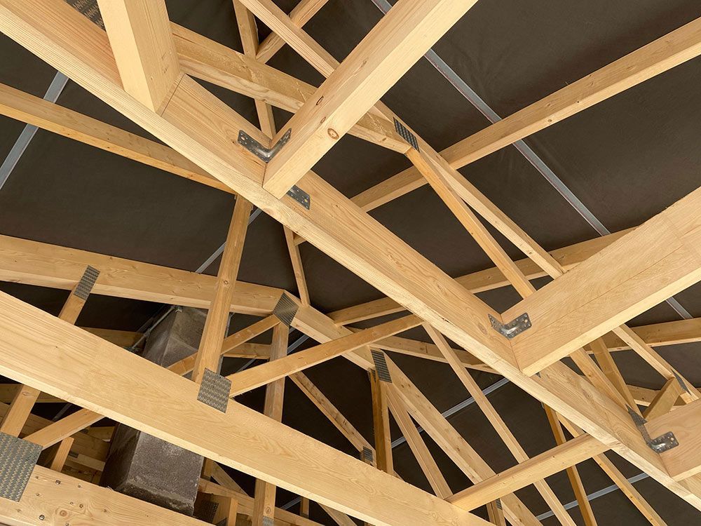 Timber roof trusses with metal bracket connections and sarking, viewed from below