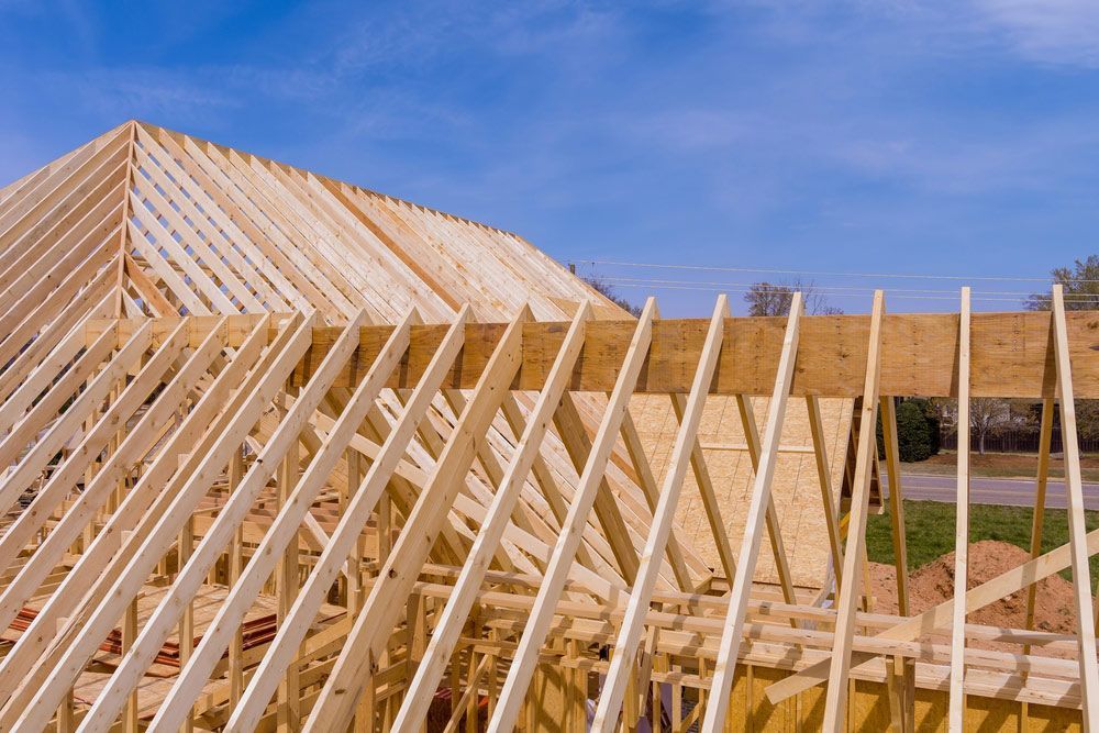 Beams Roof Trusses Frame An Exterior View Of A Framed Building Construction Of New Wooden House — Trussted Frames & Trusses in Central Coast, NSW
