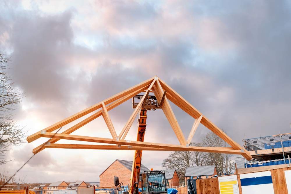 A Crane Is Lifting A Wooden Structure At A Construction Site — Trussted Frames & Trusses in Port Macquarie, NSW