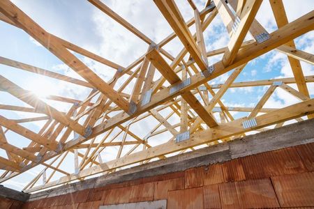 The Roof of A House Is Being Built with Wooden Beams — Trussted Frames & Trusses in Bennetts Green, NSW